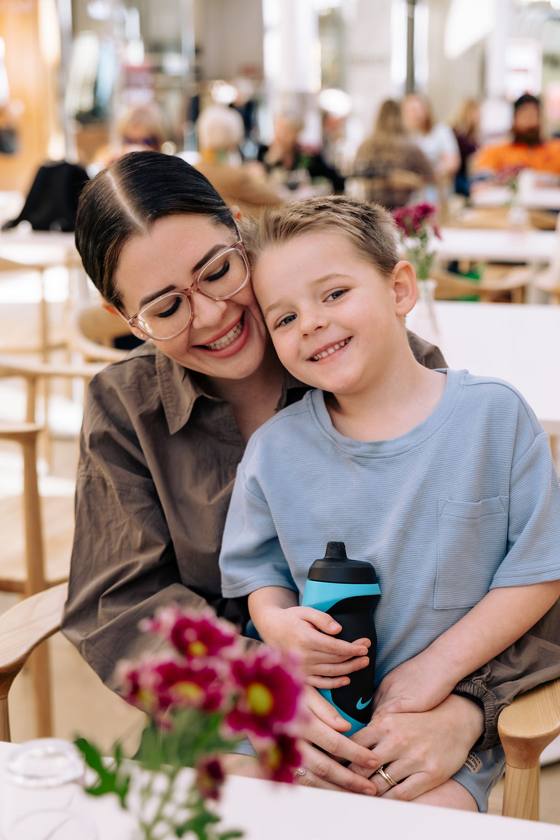 A mum cuddling her young son at a Wanna Grab a Coffee morning in Adelaide, where kids are welcome