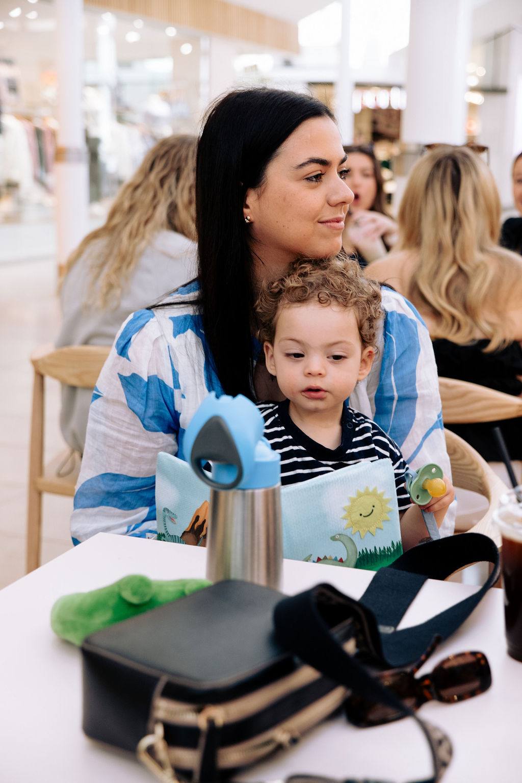 A mum with her toddler on her lap at a Business Mums Hub coffee morning in Adelaide
