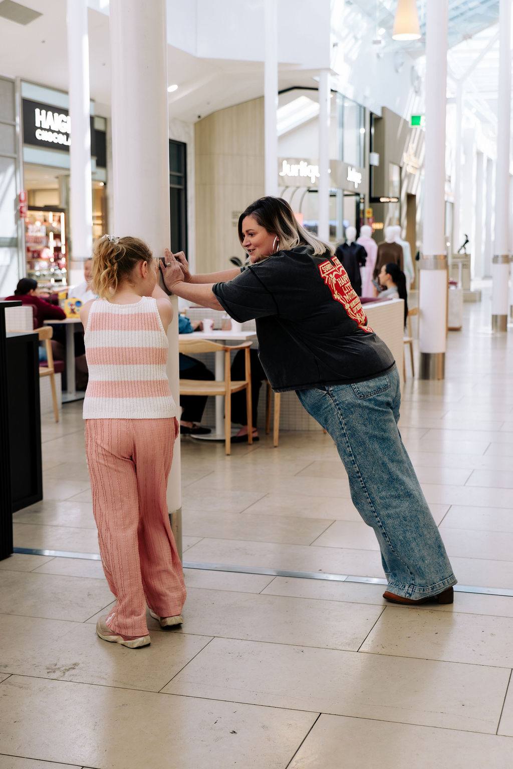 Sandra playing with her daughter around a pillar at an Adelaide shopping centre