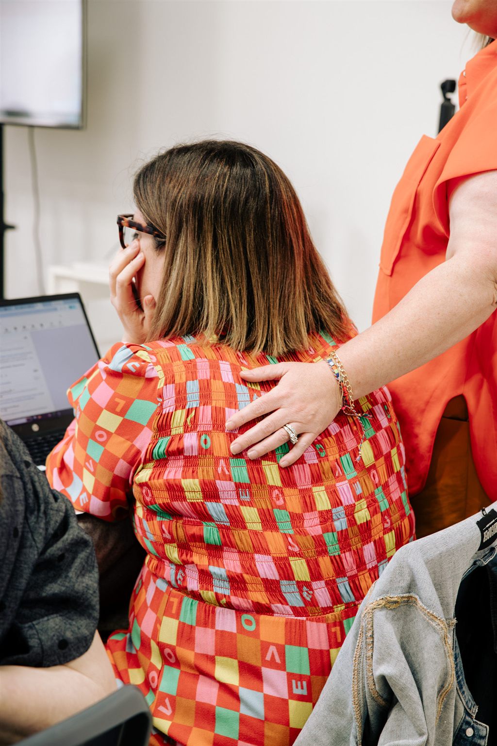 Sandra with her hand on the back of a woman at her laptop during the Claude Foundations day in Norwood